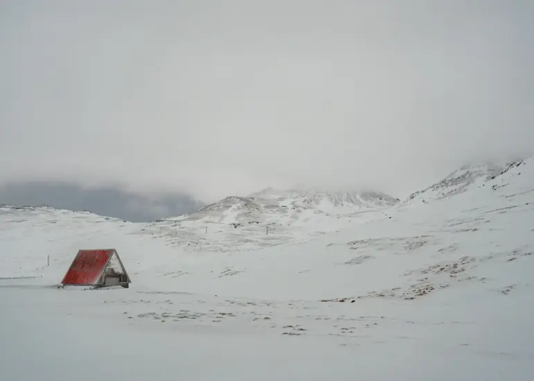 kleines Haus im Schnee auf einem Berg auf Island