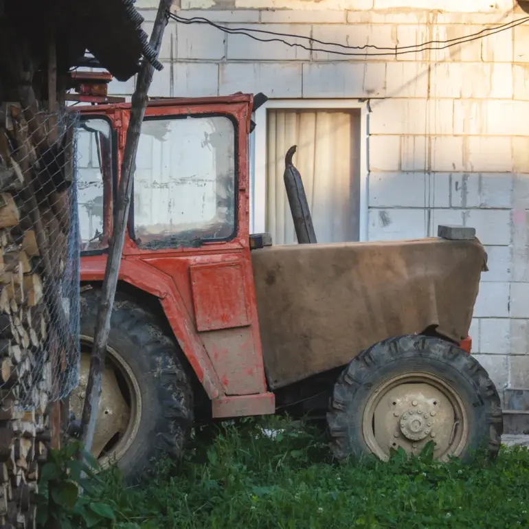 Alter Traktor vor einem Haus